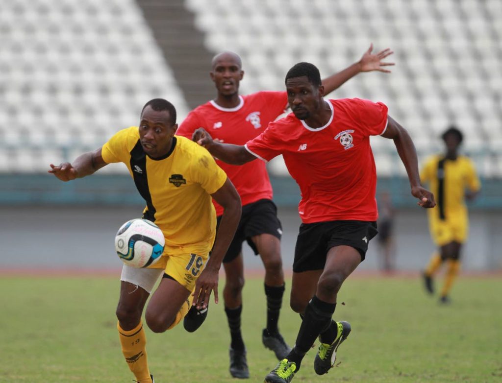 Cunupia FC striker Kevon Woodley, left, on the attack against Club Sando at the Larry Gomes Stadium, Arima, recently. 