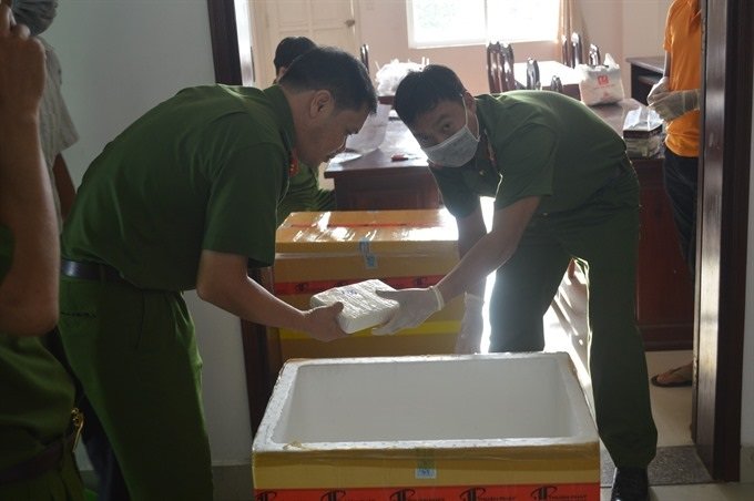 FOUND: Vietnamese police officers unload packages of cocaine found inside a Liberian-flagged vessel on Tuesday.