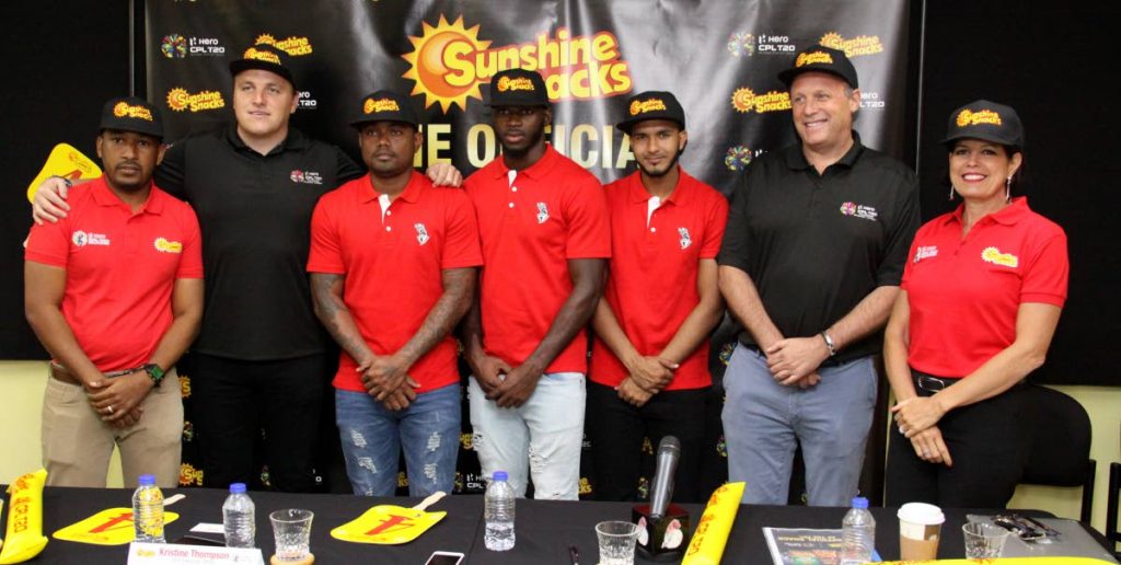 Officials from Sunshine Snacks and CPL, as well as members of the Trinbago Knight Riders pose with their Sunshine Snacks caps at yesterday's media conference. In photo are (left-right) Andrew Bascombe, brand manager of Sunshine Snacks; Damien O'Donohue, CPL CEO, TKR players Terrance Hinds, Anderson Phillip and Amir Jangoo; CPL Chief Operating Officer Pete Russell and Kristine Thompson, Sunshine Snacks CEO.