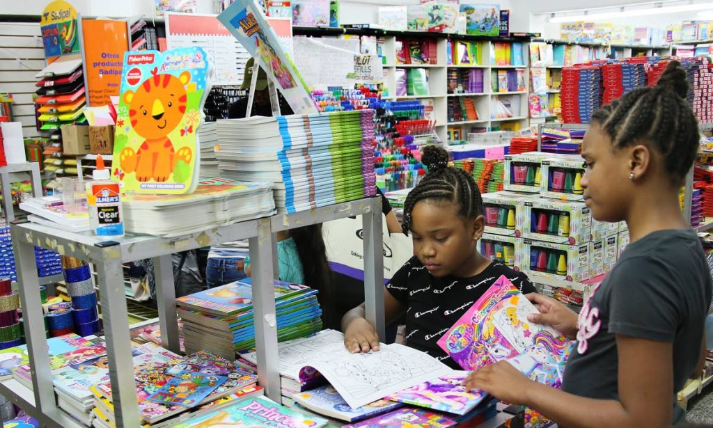 Sisters Nefertiti, left, and Kiara Barrington browse through books at Ishmael M. Khan bookstore on Henry Street in Port of Spain.