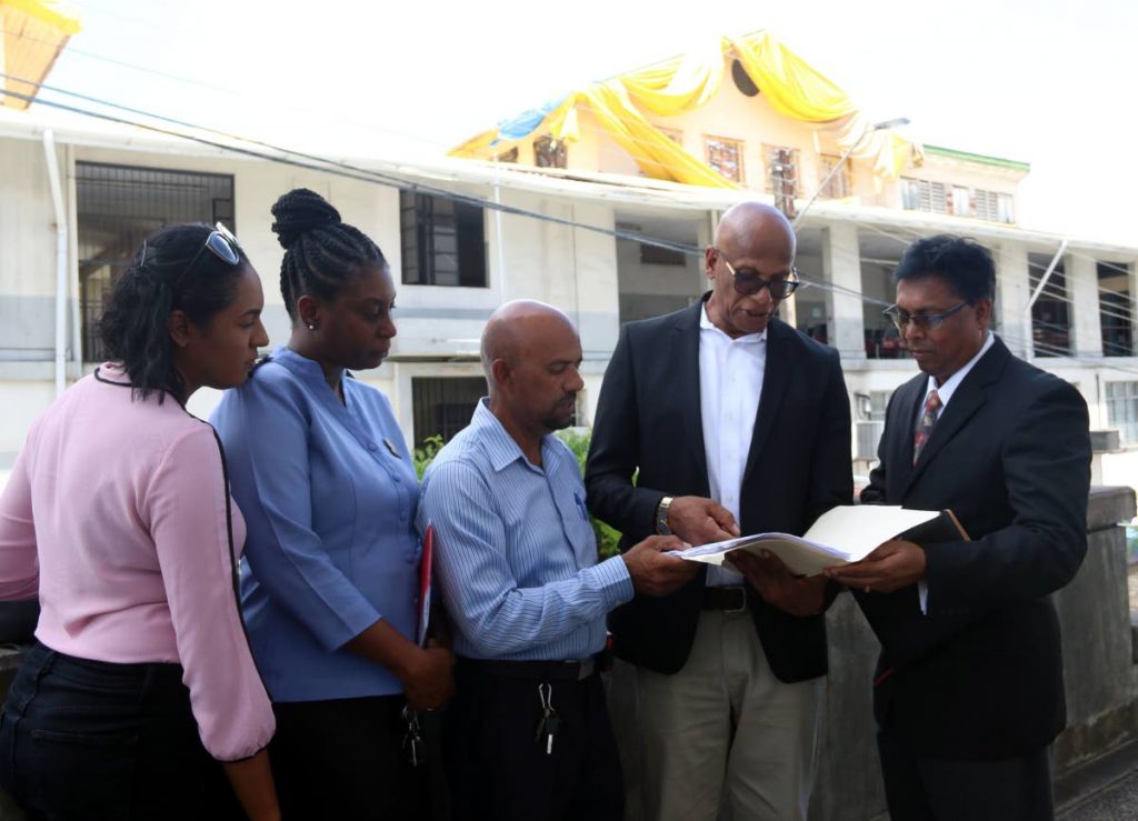CONCERN: (from left) Building inspector Candice Brooker, public health inspector Natasha Howard, building inspector David Mohammed, mayor Junia Regrello and attorney Ramesh Deena look at some documents in front of the dilapidated San Fernando Magistrates’ Court on Wednesday.