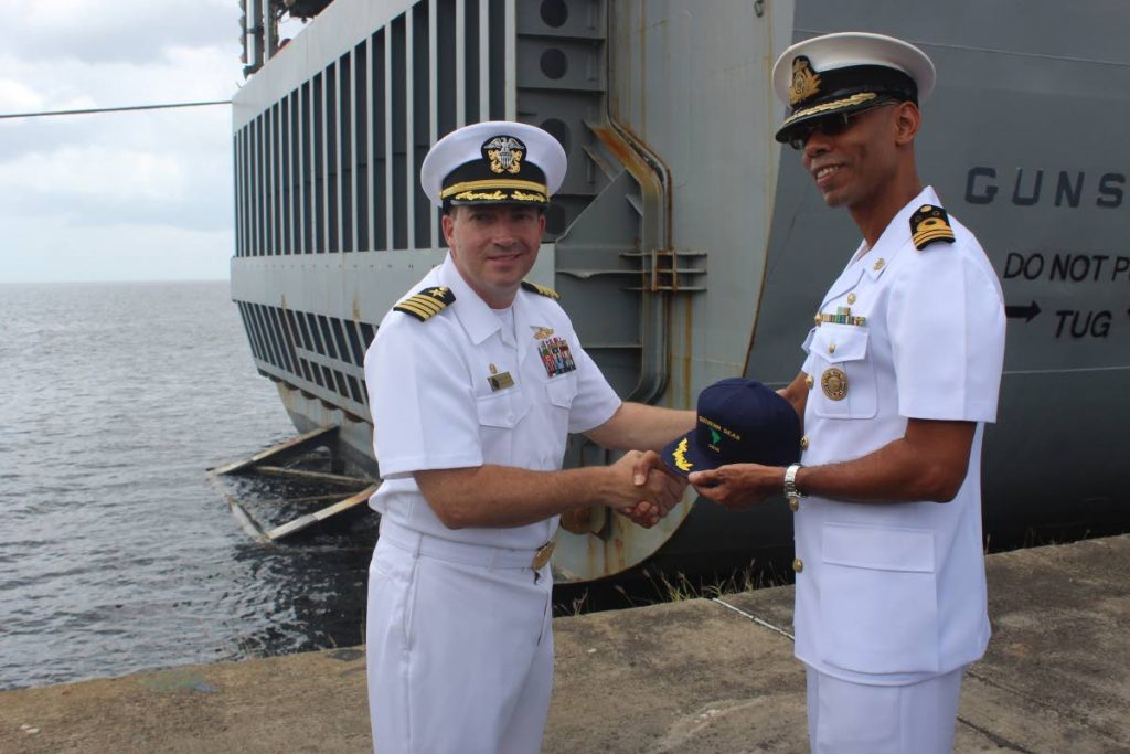 GIFT: Commanding officer of the US Navy ship USS Gunston Hall Capt Brian Diebold, left, presents a cap 
to Acting Commander of the TT Coast Guard Don Polo yesterday at the Port of Spain docks.