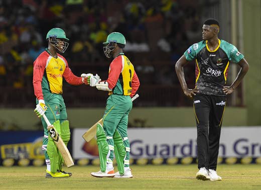 Guyana Amazon Warriors batsmen Shimron Hetmyer (left) and Jason Mohammed punch fists while St Kitts/Nevis Patriots pacer Alzarri Joseph looks on during Thursday’s CPL match. PHOTO COURTESY CPL T20