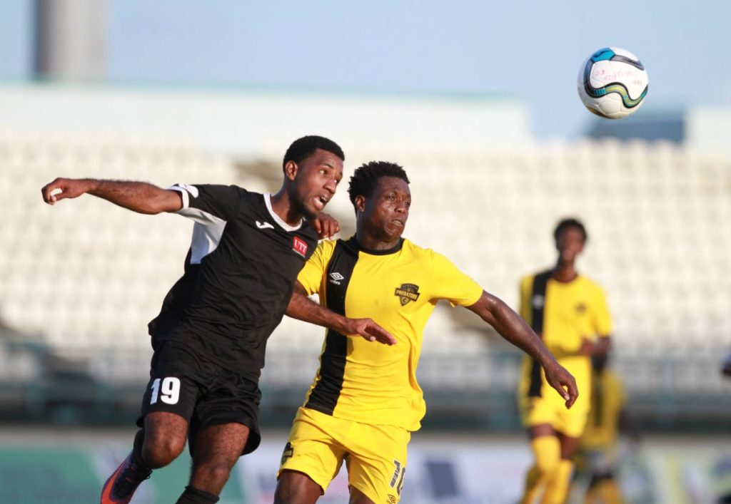 Cunupia FC's Michael Darko, right, battles UTT's Jameel Johnson in a Super League match recently at the Larry Gomes Stadium, Malabar.