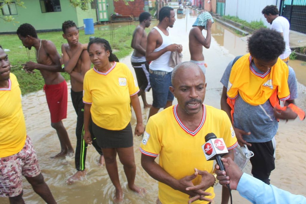 
 UNC activist Andersen Wilson (front) and a group of residents talk to the media on Tuesday after acting Attorney General and Laventille West MP Fitzgerald Hinds were chased out of the area. PHOTO BY ENRIQUE ASSOON