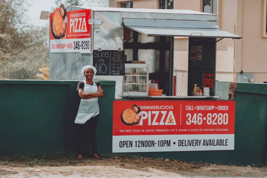 Shimone Anthony, 29, stands next to her mobile pizzeria, Shimmerlicious Pizza, Pt Sable Road, Pt D'or, La Brea.