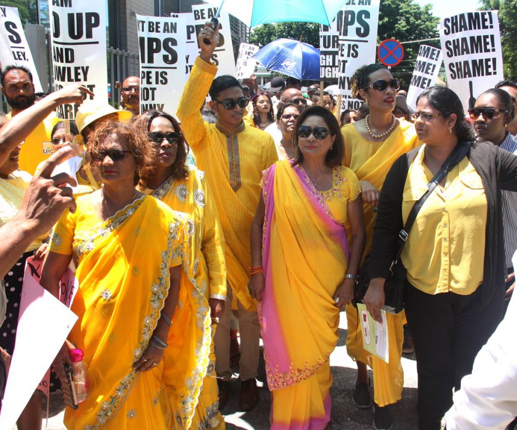 NO TO VIOLENCE: Opposition Leader Kamla Persad-Bisessar, is flanked by Deputy Political Leaders, Khadijah Ameen, right and Jearlean John, 2nd from left, as they protest in sari wear, in front the OPM, St. Clair, yesterday.