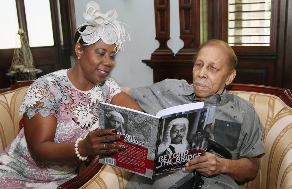 FRIENDS IN LAW: House Speaker Brigid Annisette-George browses through a copy of Beyond the Bridge with retired chief justice Clinton Bernard at his book launch at Stollmeyer’s Castle in PoS yesterday.