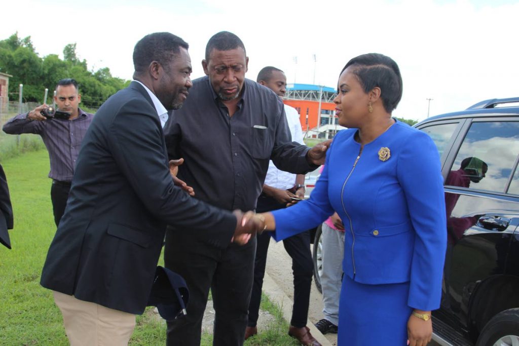 Sports Minister Shamfa Cudjoe (right) greets an official, while TTFA president David John-Williams (centre) looks on, during her tour of the Home of Football yesterday.