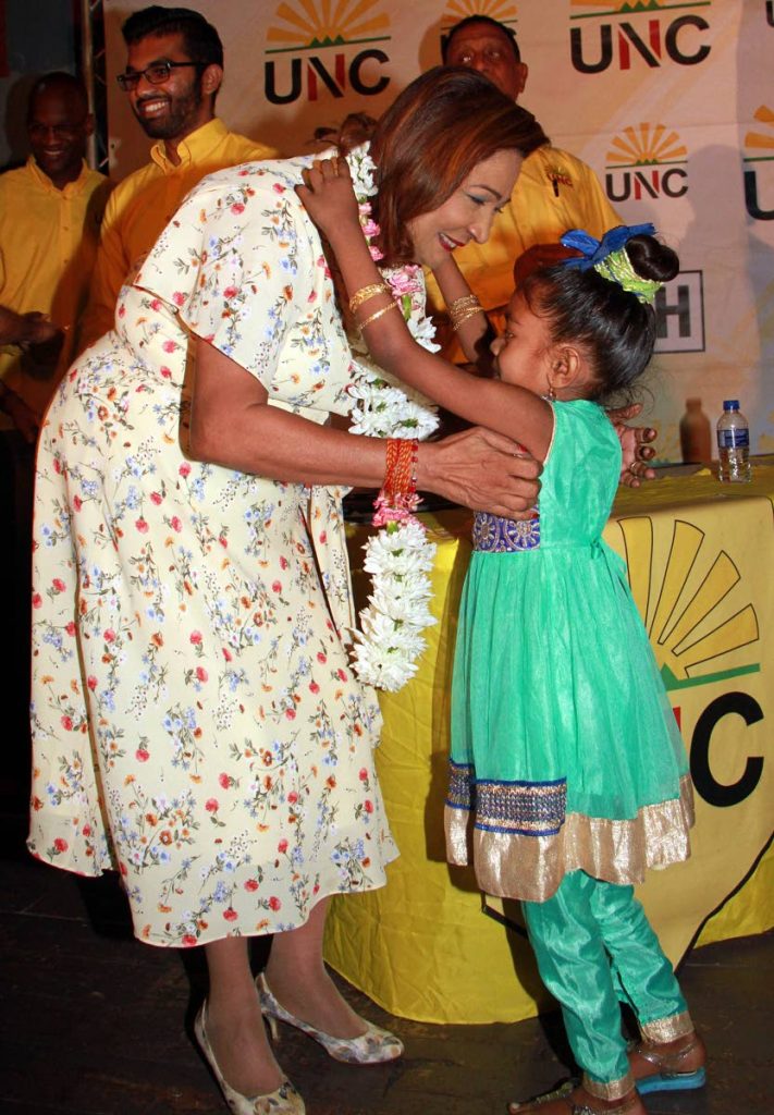Flowers for Kamla: Opposition Leader Kamla Persad-Bissessar receives a garland from six-year-old Christine Seelel during the UNC's Monday Night Forum at Chaguanas South Secondary School.
PHOTO BY ANIL RAMPERSAD. 