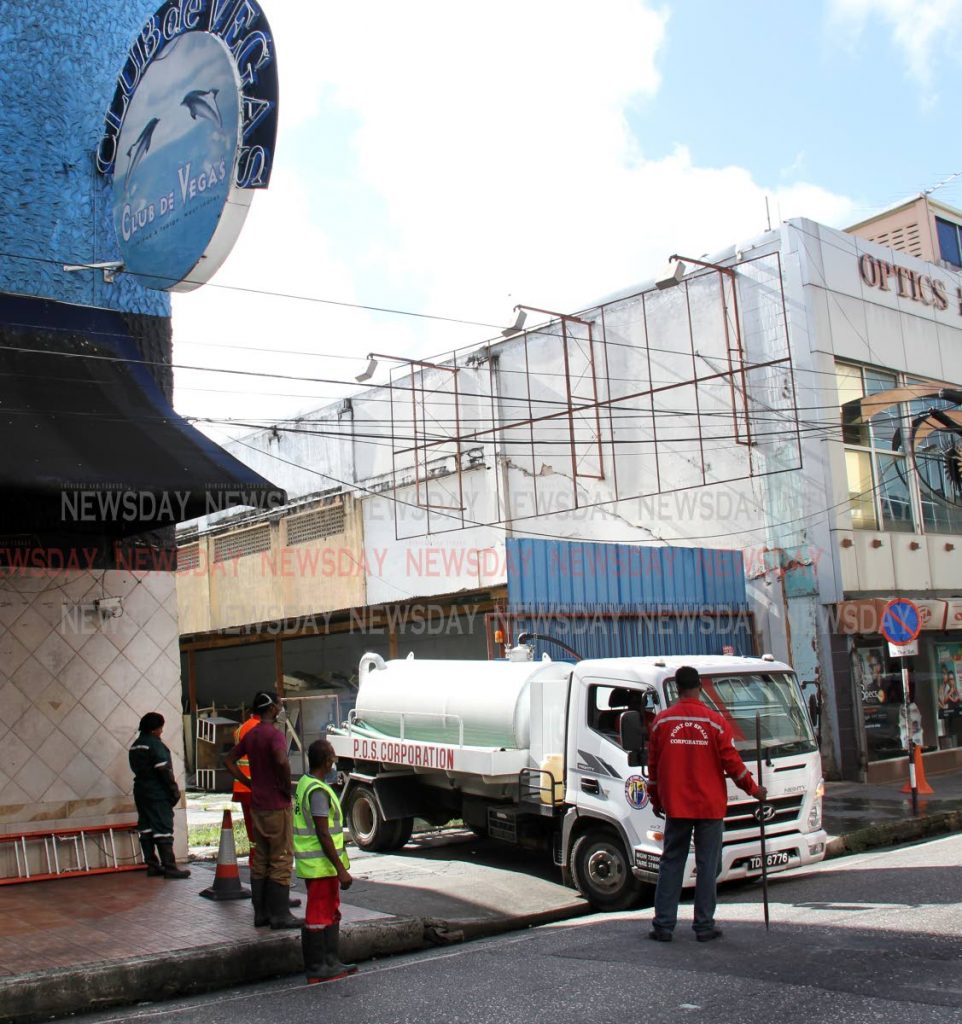 STENCH SOURCE: Workers of the Port of Spain Corporation at the compound of the once popular Club D Vega casino (now closed) at 78-80 Frederick Street to contain a sewer water leak.  PHOTO SUREASH CHOLAI