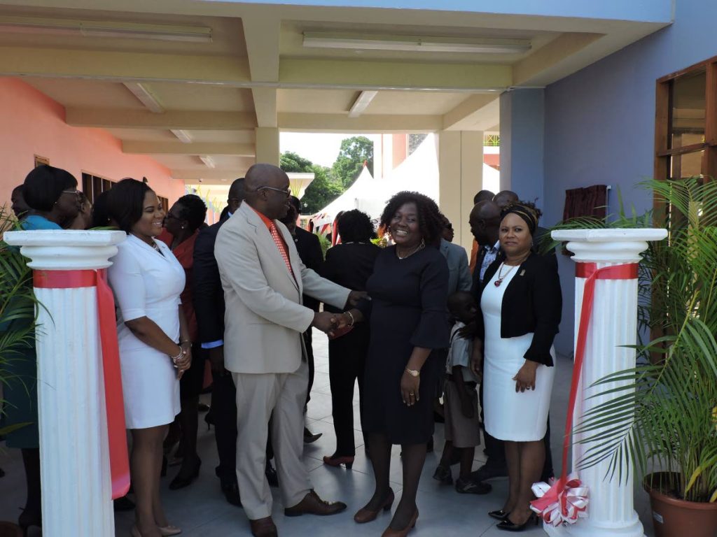 Chief Secretary Kelvin Charles shakes hands with Ag. Principal of the Scarborough Roman Catholic Primary school, Patricia Wafe, during the commissioning ceremony at Smithfield on Wednesda