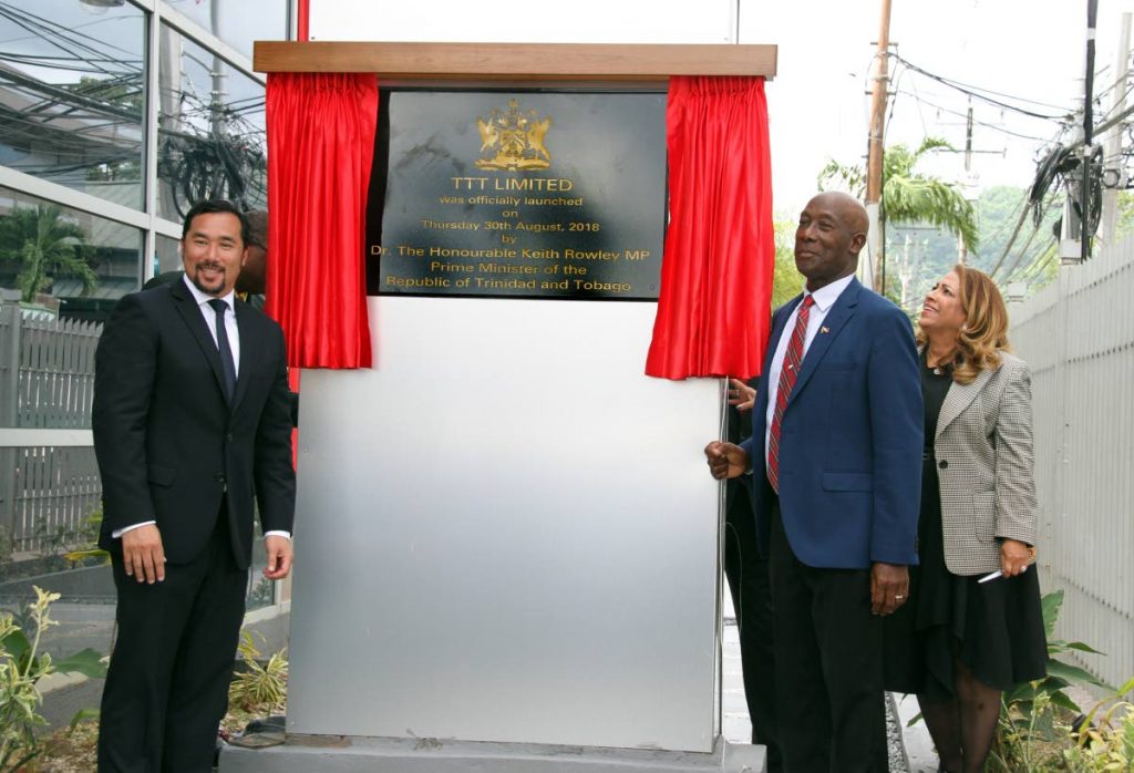 SECOND TIME AROUND: Prime Minister Dr Keith Rowley unveils a plaque yesterday to launch the new TTT Ltd at Maraval Road, Port of Spain.  With him are Communications Minister Stuart Young and TTT Ltd chairman Lisa Agard. PHOTO BY SUREASH CHOLAI