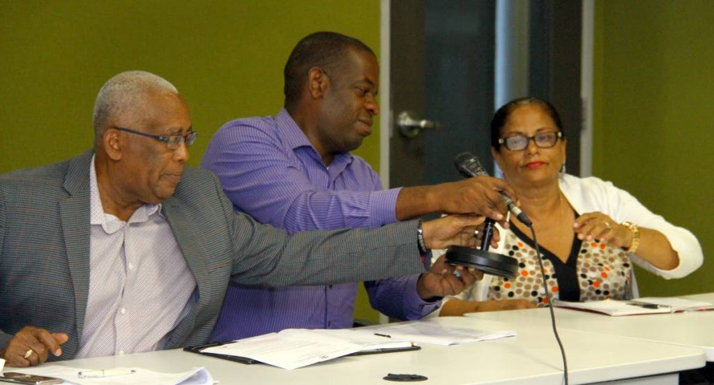 Over to you: Education Minister Anthony Garcia and Dr Lovell Francis, Minister in the Education Ministry, help to hand over the microphone to Raffiena Ali-Boodoosingh, president of the National Parent-Teacher Association during a press conference at the ministry, Port of Spain yesterday. PHOTO BY ROGER JACOB
