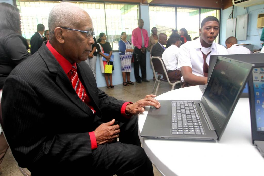 BACK TO SCHOOL: Education Minister Anthony Garcia tries out one of the laptops he and Minister in the Ministry Dr Lovell Francis presented to the Ste Madeleine Secondary School yesterday.
