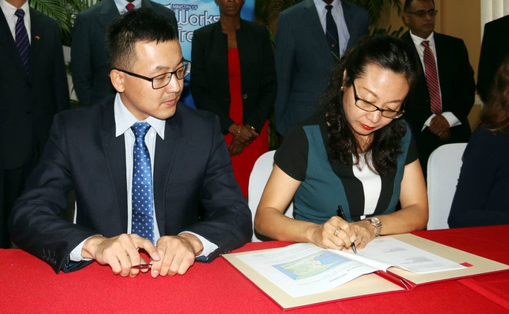 Xuewu Gao (left) and D Zhimin Hu of China Harbour Engineering Company sign the agreement to build a dry docking facility in La Brea. Rui Wang, senior business and regional manager of the Eastern Caribbean, CHEC Americas Division, projected that the project will generate foreign exchange in excess of US$500 million.