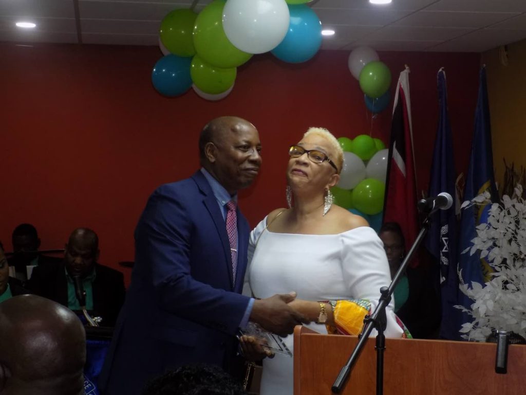 Former acting police commissioner Stephen Williams, left, kisses secretary general of the TT Police Service Retiree’s Association Julie Carrington as he receives an award at a retirement dinner in Port of Spain yesterday.