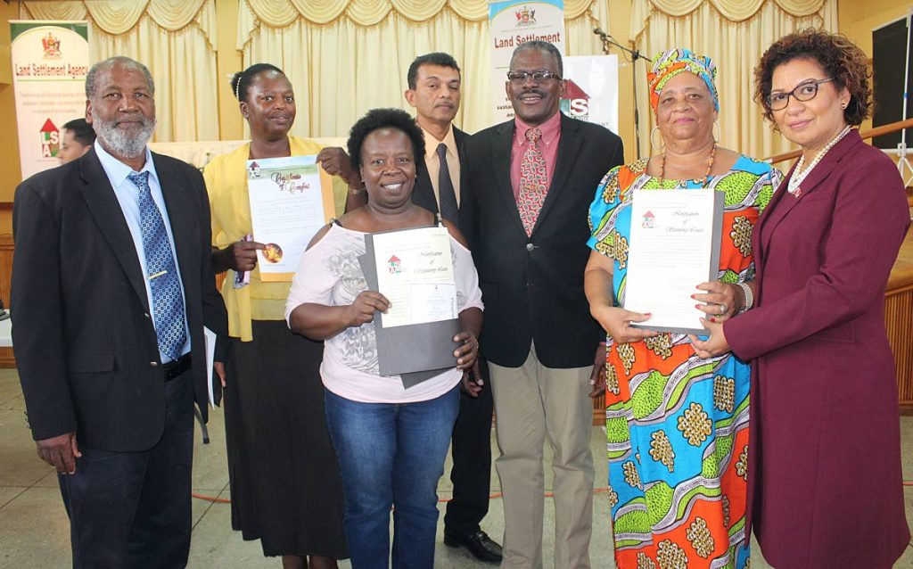 SMILES ALL AROUND: Housing Minister Edmund Dillon, 3rd from right, MP Glenda Jennings-Smith, right, LSA chief executive officer Hazard Hosein, centre, and Ossley Francis, left, with three women who received certificates of comfort on Tuesday.