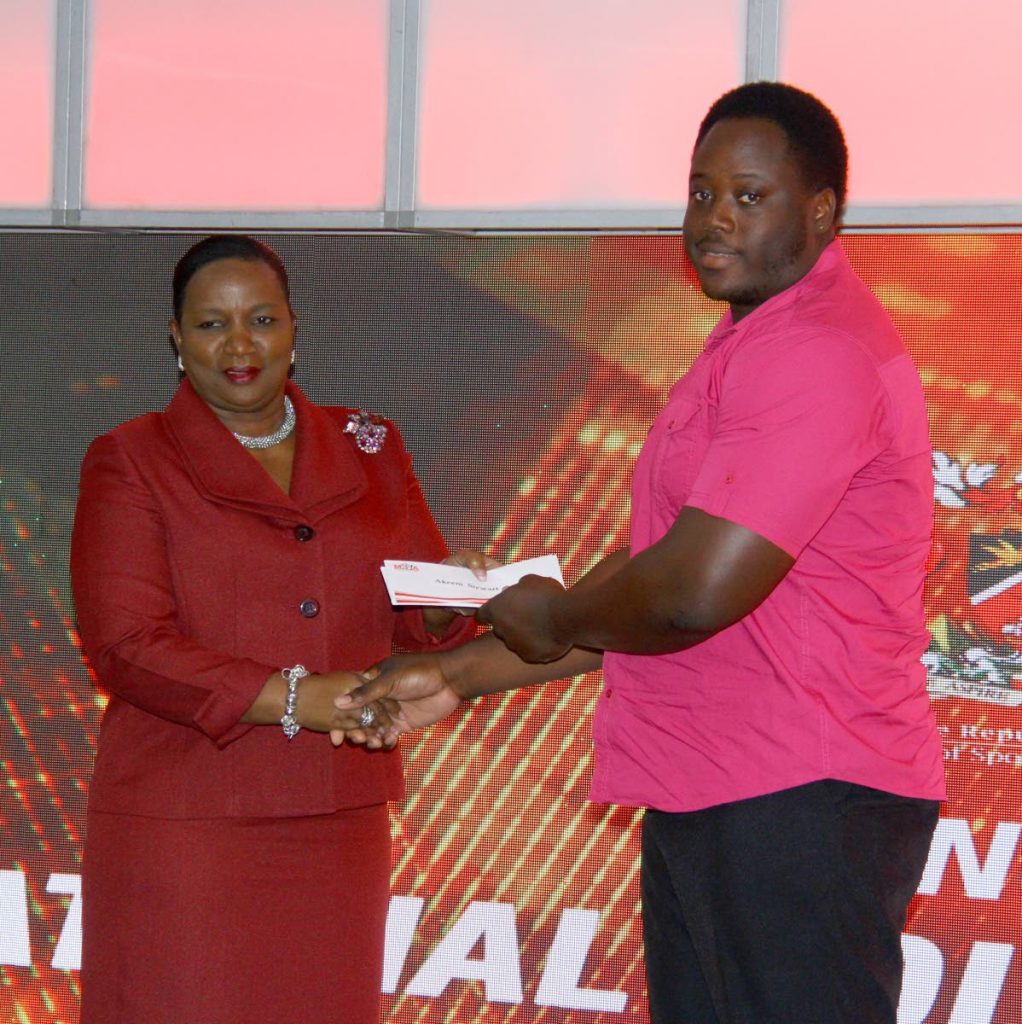 Paralympic champ Akeem Stewart, right, collects his cheque from Minister of Social Development Cherrie-Ann Crichlow-Cockburn. PHOTO BY ROGER JACOB 