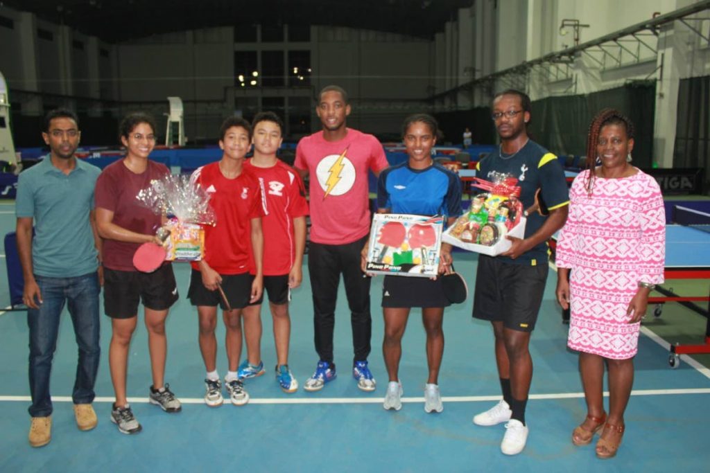 A representative from sponsor Sawh Electronic, left, poses with UTT lecturer Dr Karen Ince, right, and players (left-right) Catherine Spicer, Nicholas Lee, Nicholas O Young, Shermar Britton, Brittany Joseph and Andrew Edwards at Sunday's fund-raising table tennis tournament at the National Racquet Centre, Tacarigua.
