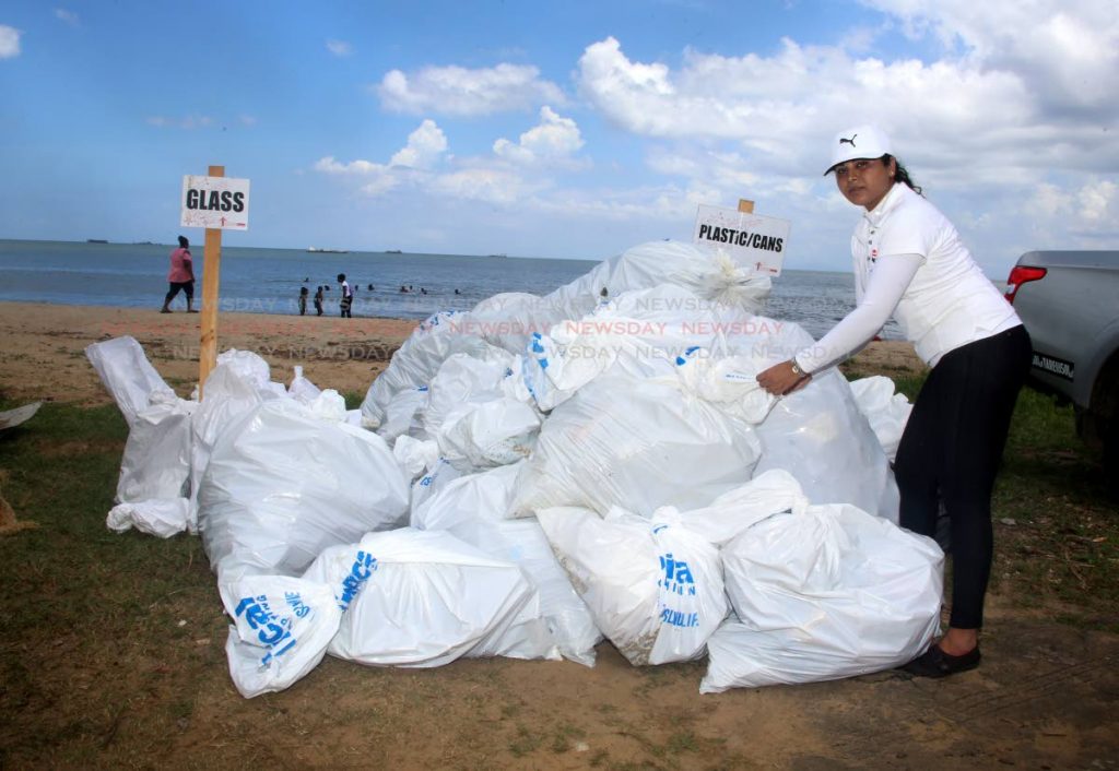 NGC employee Kavita Harry stacks garbage bags as part of a clean-up of Station Beach, La Brea. 