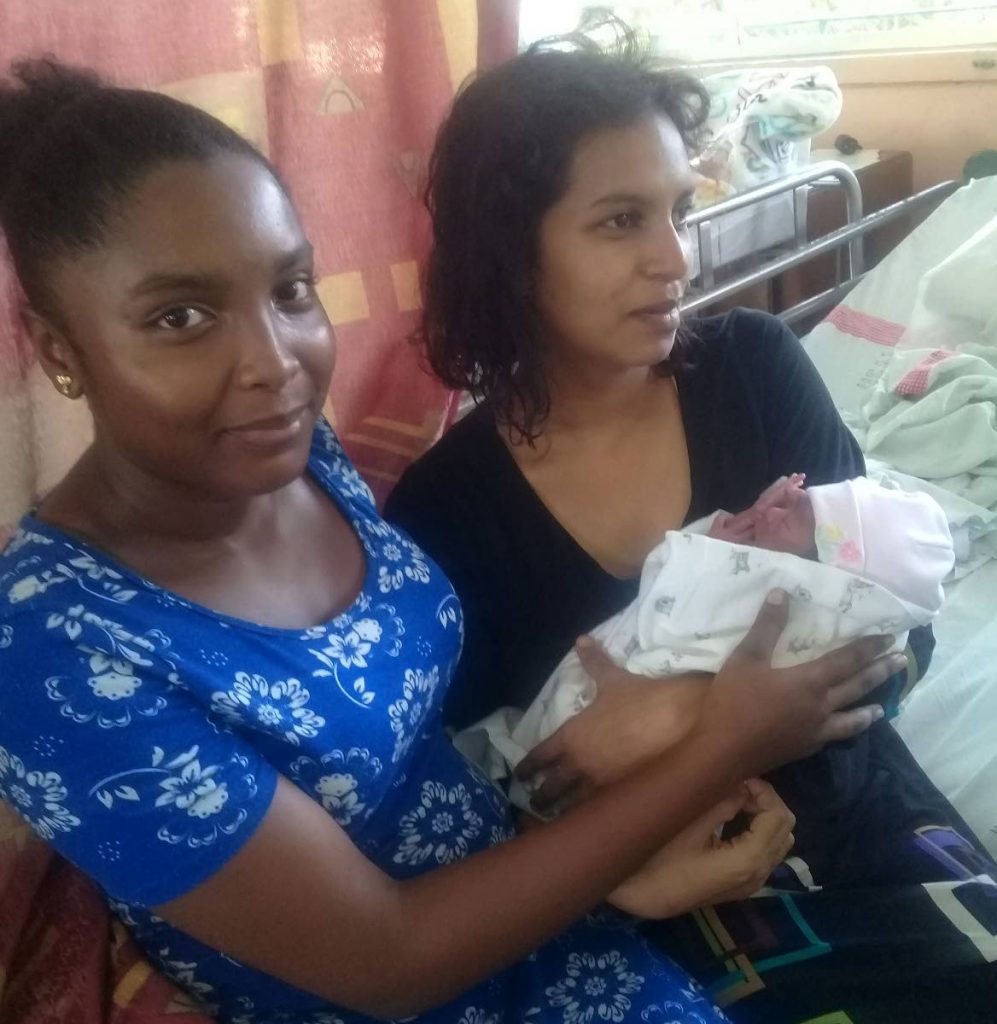  Comelia Joseph visits her aunt Summer Norman and her baby girl at San Fernando General Hospital yesterday. Joseph delivered the baby while paramedics told her what to do over the phone when Norman went into labour at her home in Tabaquite last Friday. PHOTO BY VASHTI SINGH