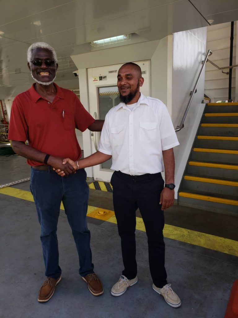 File photo: NIDCO’s Chairman Herbert George, left, shakes hands with Allister Khan, local captain aboard the Galleons Passage following its second trial run to Tobago last September.