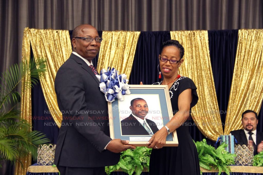  Police Social and Welfare Association member  Ederis Johnson presents former acting commissioner of police Stephen Williams , a framed protrait of himself at an appreciation ceremony for Williams by Association at the Hyatt in Port of Spain on Saturday evening. PHOTO SUREASH CHOLAI. 