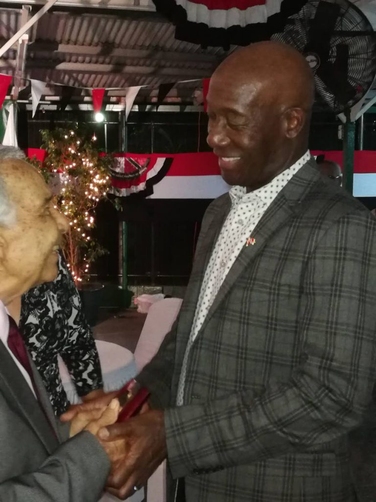 Prime Minister Dr Keith Rowley warmly greets Oliver Camps, patron of the Harvard Club, at its 75th anniversary function on Saturday. 
