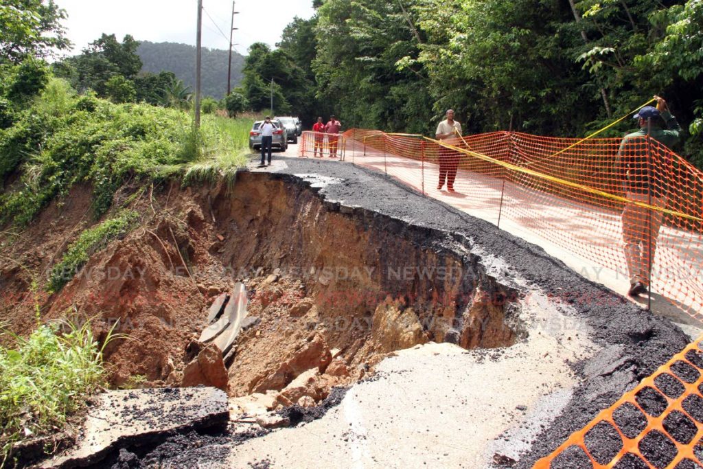 Officials of the Ministry of Works along the North Coast road just  before Maracas beach where a hugh section of the roadway  has  slip away after heavy rainfall earlier in the week, only one way traffic can proceed at this time. PHOTO SUREASH CHOLAI