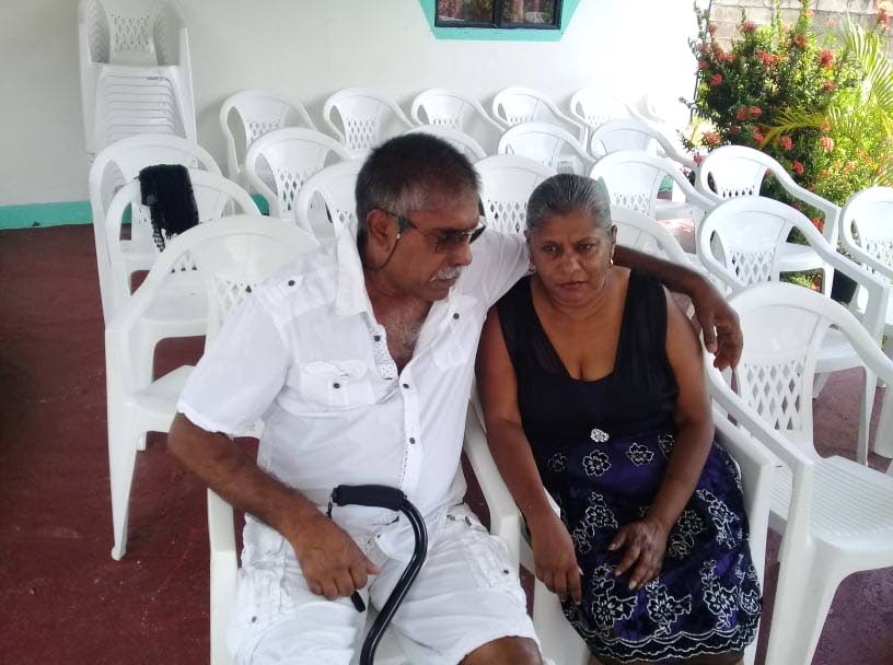 Zainool Ali, left, consoles his wife Jennifer Ali as they await the arrival of guests for their son, Sharard Garraway's funeral at the family's Hingoo Trace, El Socorro, home this morning. 