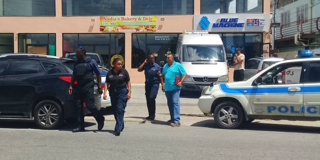Security guards with G4S security company are led across the street by Inspector Ganga Singh after they were robbed of their cash and weapons by bandits at the St Helena Republic Bank yesterday.