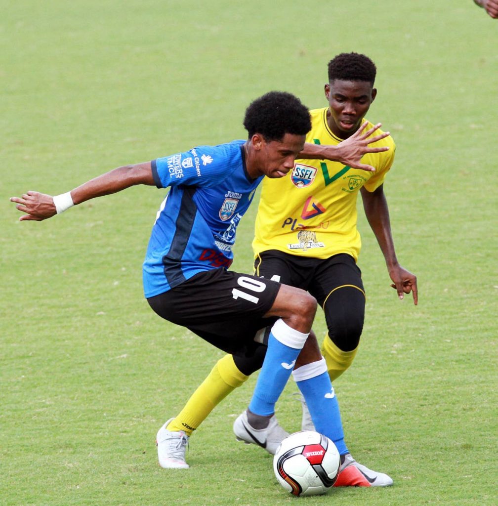 At left, Jordan Riley of Presentation College, San Fernando and Kareem Phillip of St. Benedict’s College battle for the ball during an SSFL match, which took place yesterday, at Mannie Ramjohn Stadium, Marabella.
