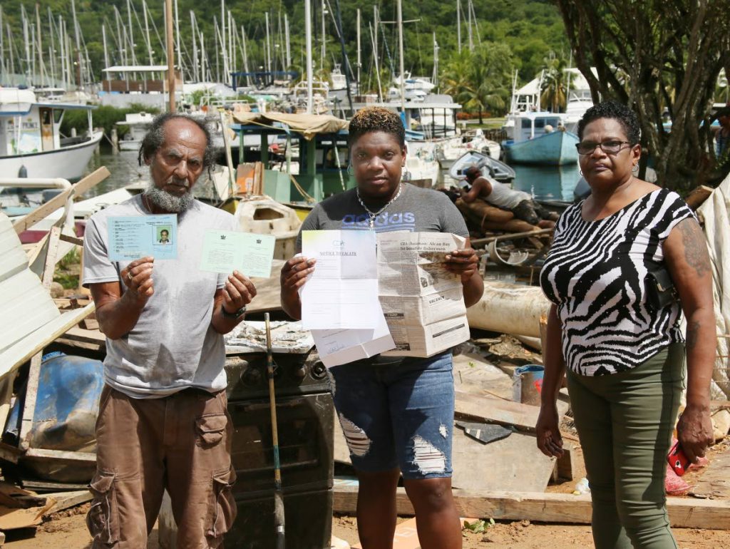 OUR EVIDENCE: Norbitt Joseph, left, and other finshermen display their documents which they claim authorises them to operate at the Alcan fishing depot in Chaguaramas. PHOTO BY AZLAN MOHAMMED