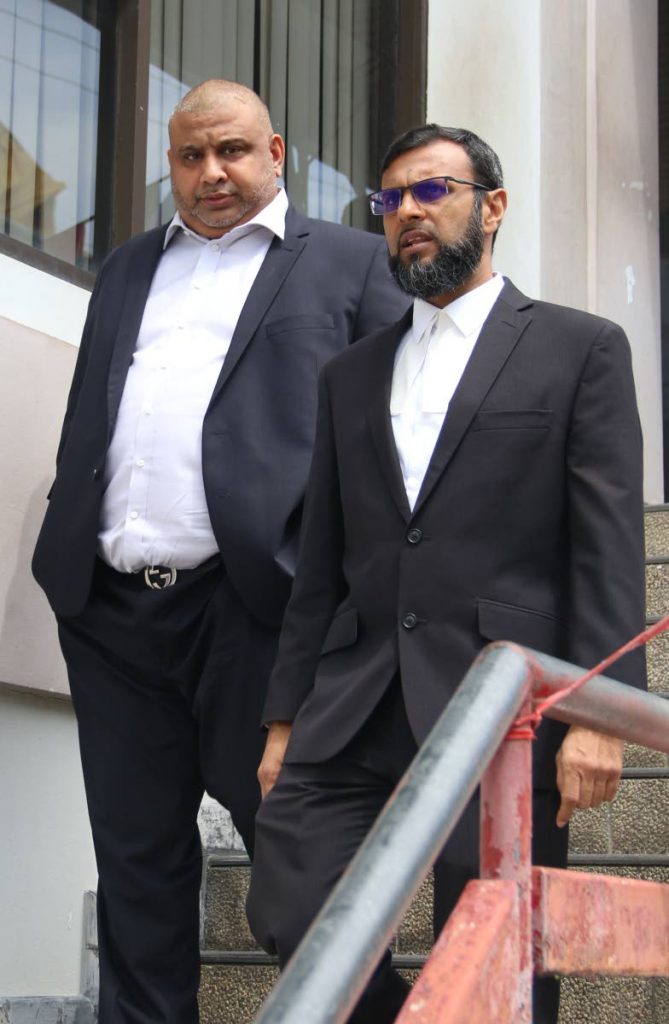 Malik King, left, leaves San Fernando High Court with his attorney Imran Khan yesterday after winning his claim against the owner of a funeral home.
