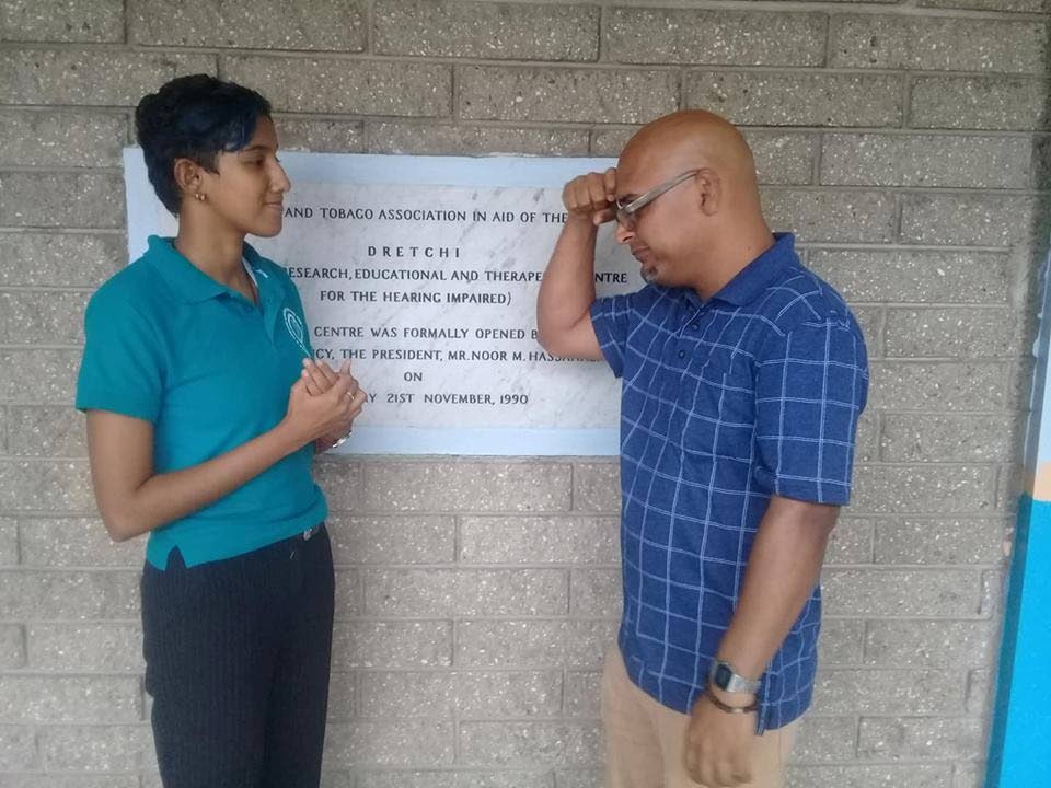 Sign language researcher Ian Dhanoolal (right) signs with Trinidad and Tobago Association for the Hearing Impaired (TTAHI) communications assistant Maya Ramesar at TTAHI's offices, Port of Spain last week. 