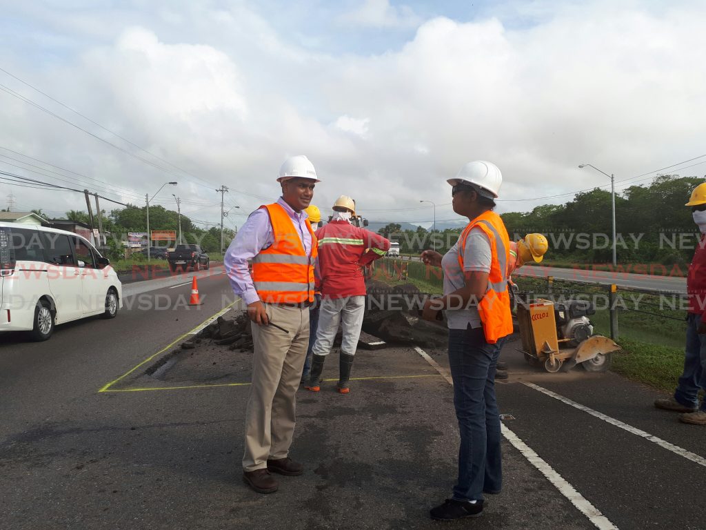 Coosals Operations Manager Glenn Mahabirsingh speaks to Chief Engineer (Roads) at the Ministry of Works and Transport Katherine Badloo Doerga while workers repaired a patch on the northbound lane  of the Uriah Butler Highway. Photo by Kalifa Sarah Clyne