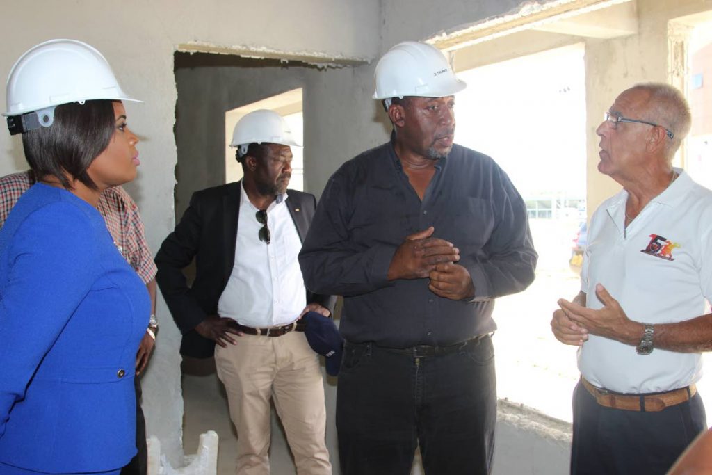 TTFA president David Jhn-Williams,2nd right, discusses the ongoing work at the Home of Football, in Balmian, Couva with Douglas Camacho,right, and Minister of Sport and Youth Affairs Shamfa Cudjoe,left, during a tour of the facility, on August 19. In the background, FIFA representative  Veron Mosengo-Oba looks on.