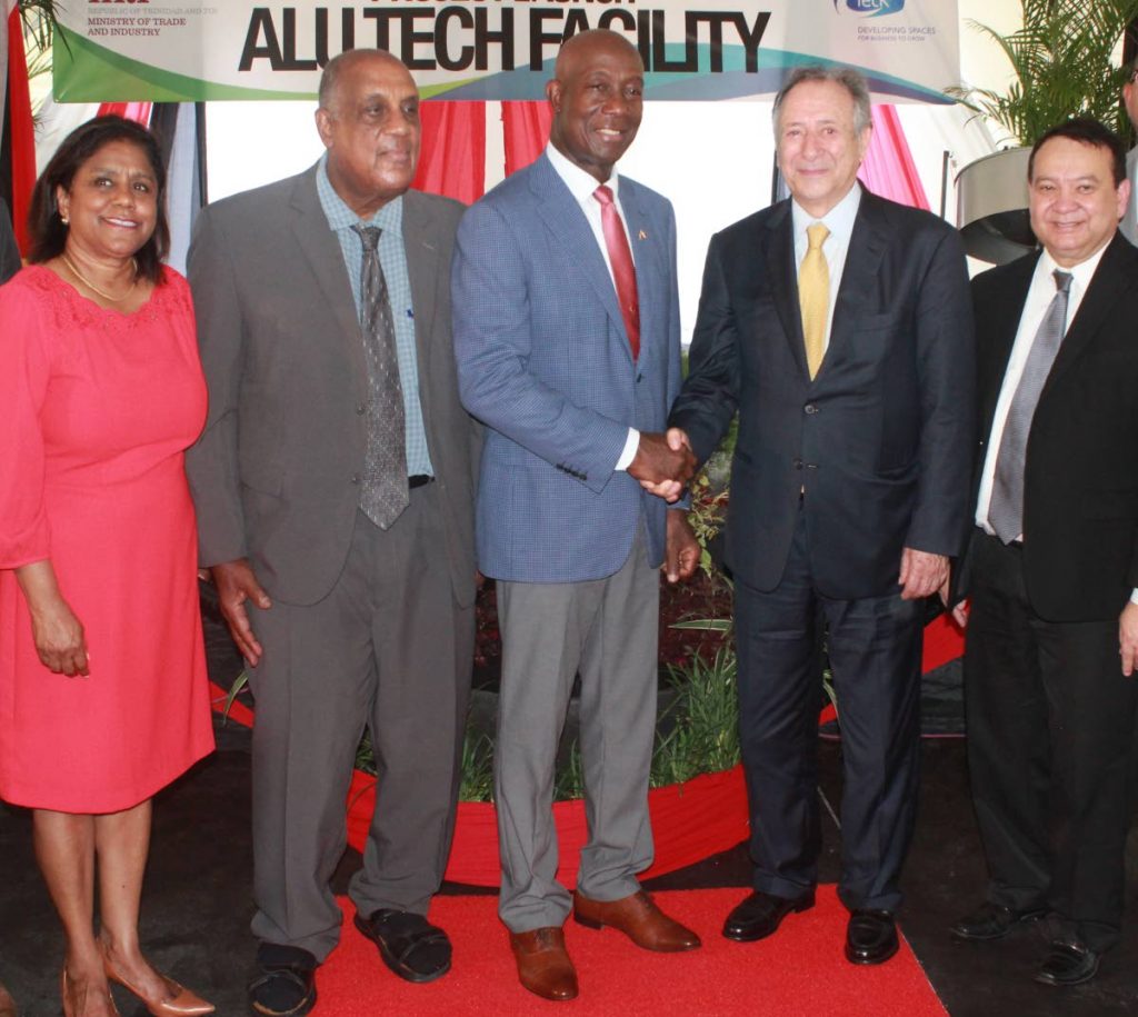 Shake on it: Prime Minister Dr Keith Rowley and Alfredo Riviere, president and CEO of Sural shake hands at the launch of the launch of the Alutech research and development project in Wallerfield on October 3. Also in photo are Trade minister Paula Gopee-Scoon, Alutech chairman Ken Julien and Energy minister Franklin Khan. Photo by Enrique Assoon