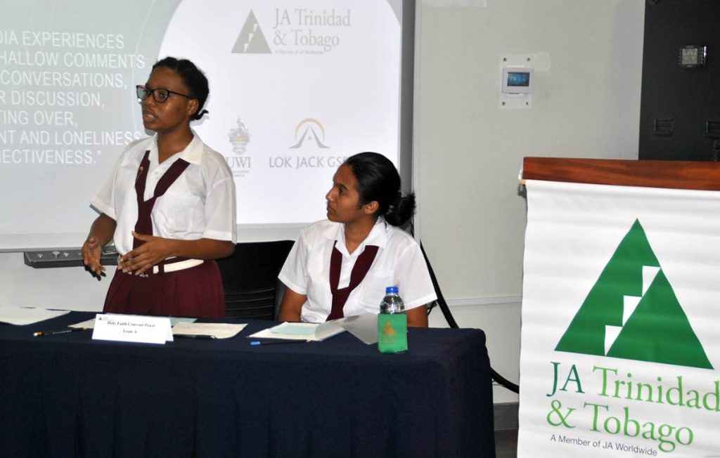 Marylee Ann Cruickshank, lead debater for Holy Faith Convent, Penal A team, makes a point during the preliminary round of the 2018 Junior Achievement Leadership Debate series, while her colleague,
Chelsea Maloney, follows her argument.