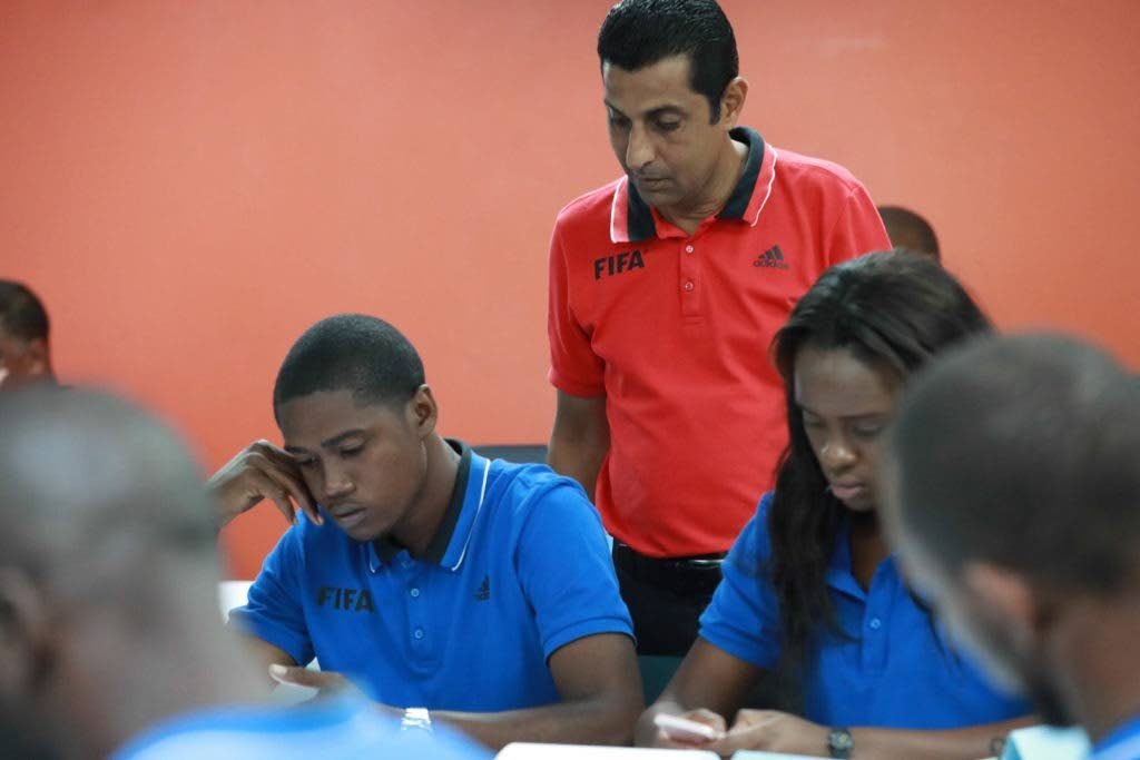 Michael Ragoonath (centre) looks at a few officials during a recent course.