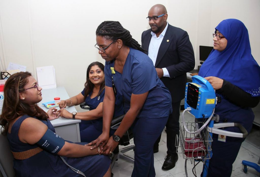 IN GOOD HANDS: Diabetes educator Jamila Billy-Thomas attends to Anisa Gaffoor at the diabetes wellness centre at Mt Hope yesterday.  Looking on are Davlin Thomas - CEO of the NCRHA and Reona Bootkoon and Cheryl Ramsamooj.   PHOTO BY AZLAN MOHAMMED