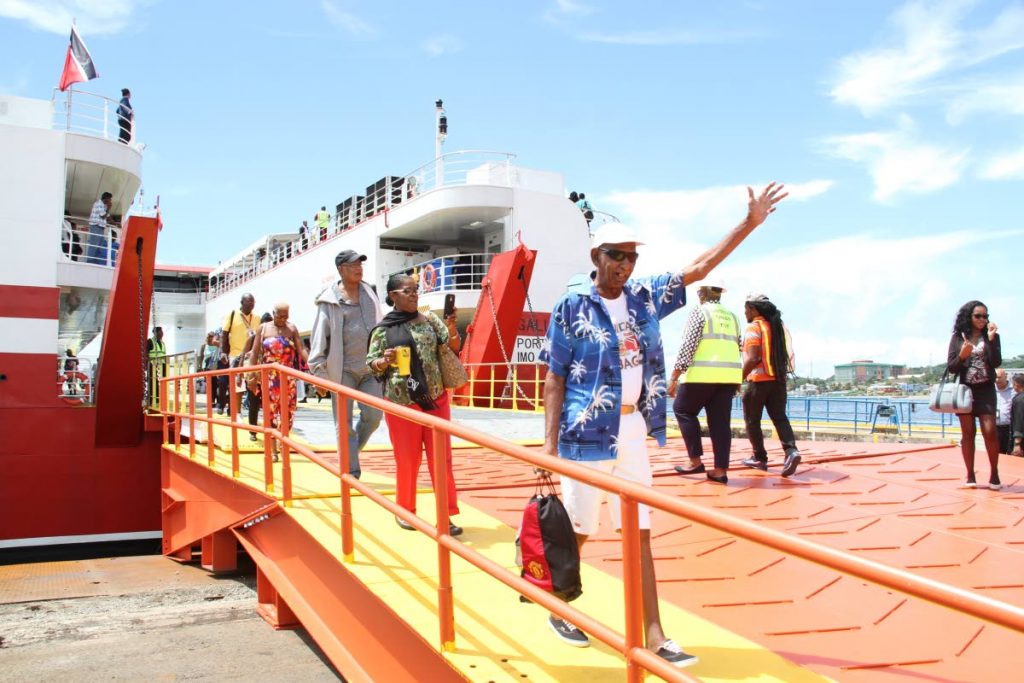 LAND HO!: This man, one of the first to disembark, waves as he leaves the Galleons Passage shortly after it arrived at the Scarborough port yesterday after its maiden commercial sailing from the Port of Spain port.