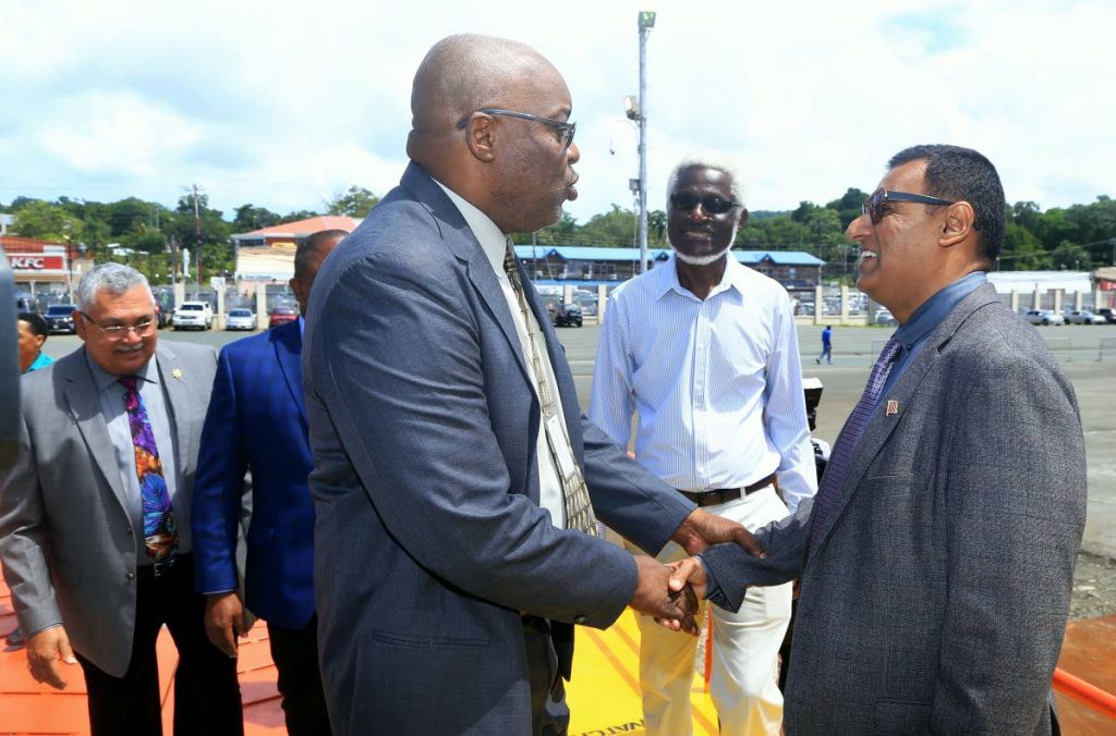 Works and Transport Minister Rohan Sinanan right, greets Chief Secretary Kevin Charles on Monday at the Scarborough port following the docking of the Galleons Passage on its first official journey on the sea bridge. Photo by SUREASH CHOLAI