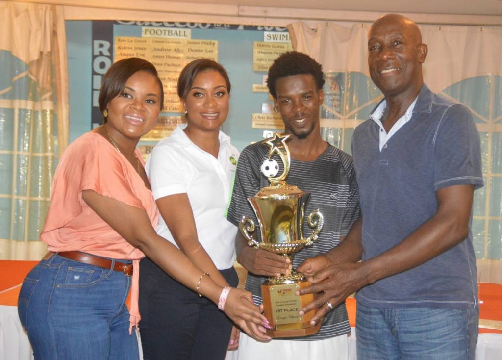 Micah Lansiquot, second from right, captain of Mt Pleasant FC, league champions of the 2018 BPTT-sponsored Carenage All-Star Football League, proudly displays the championship trophy, with Prime Minister Dr Keith Rowley, right, Minister of Sport and Youth Affairs Shamfa Cudjoe, left, and Rachael Caines, BPTT representative.