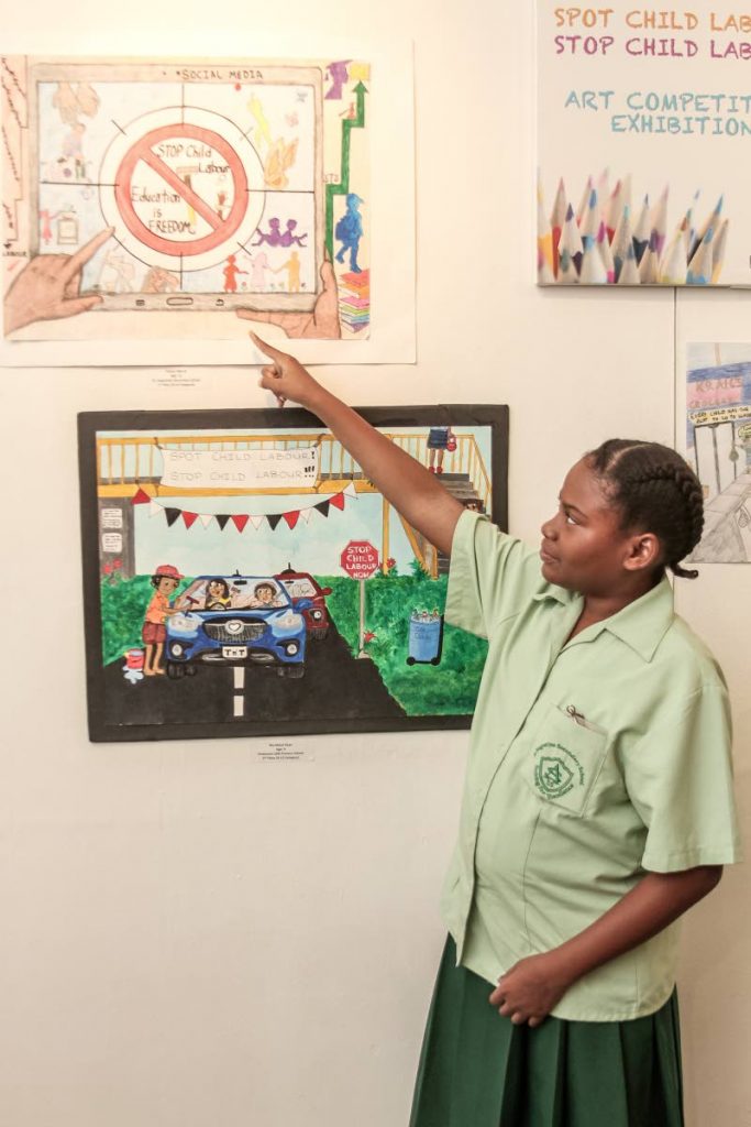 St Augustine Secondary School student Ellania Morris, at the Art Society of TT in St Clair on September 28, explains the concept of her drawing on child labour which won the 8-12 age category of the Ministry of Labour's art competition. PHOTOS BY JEFF K MAYERS