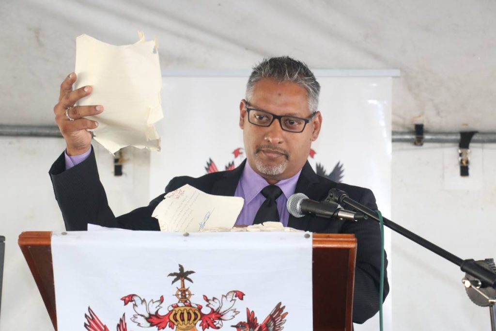 Agriculture Minister, Clarence Rambharat, shows those present at the launch of the Land Card, the state of some of the old files at the Land Management Division. PHOTO COURTESY THE MINISTRY OF AGRICULTURE, LAND AND FISHERIES