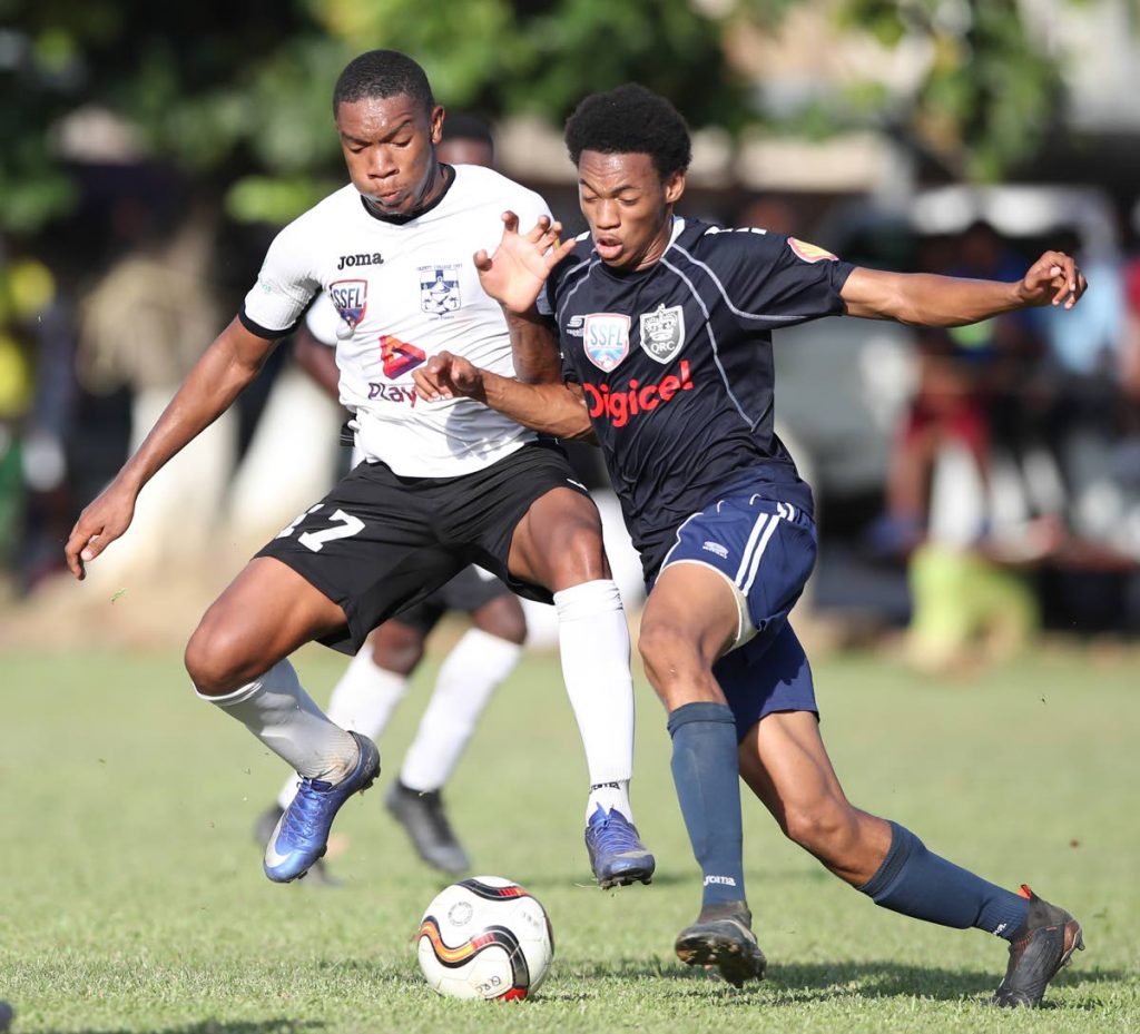 QRC's Kalev Kiel (right) atempts to go past Trinity's Christian Ransome (#17) during Match day 9 of the SSFL between QRC and Trinity College (East) at QRC Grounds, St. Clair,yesterday. The match ended 1-1. Photo: Allan V. Crane/CA-images