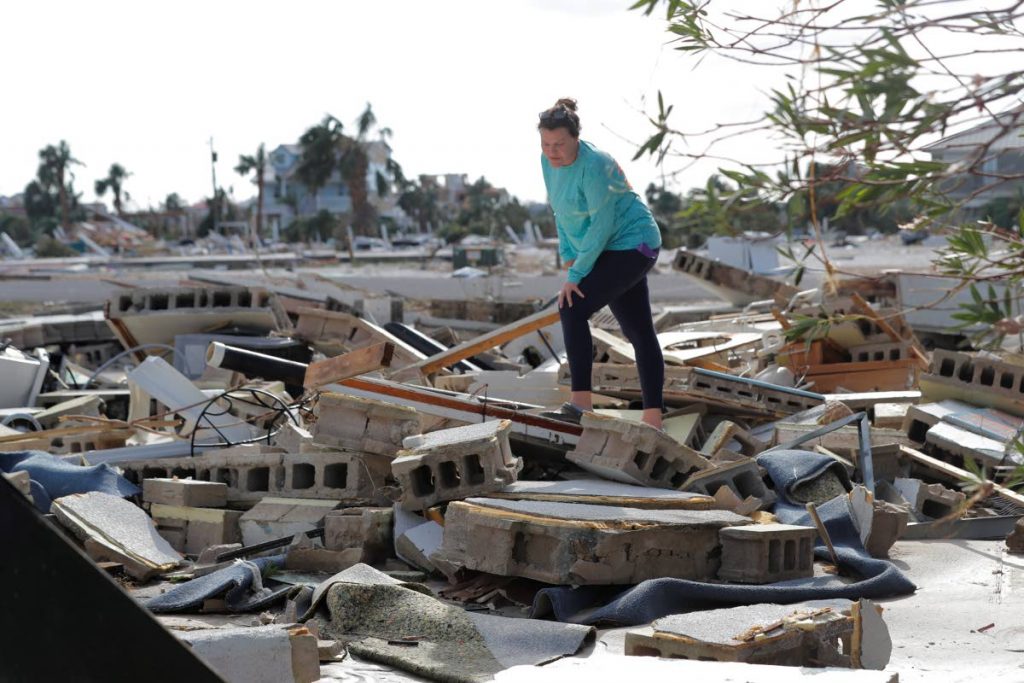 In this October 11, 2018 file photo, Mishelle McPherson looks for her friend Agnes Vicari in the rubble of her home in Mexico Beach, Florida. Vicari stayed in her home during Hurricane Michael and had not been found. The storm that ravaged the Panhandle left incredible destruction. AP Photo