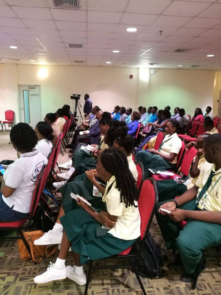 
Students of the Signal Hill Secondary school listen to a  presentation by domestic abuse survivor Stacy-Ann Beckles at a symposium, 